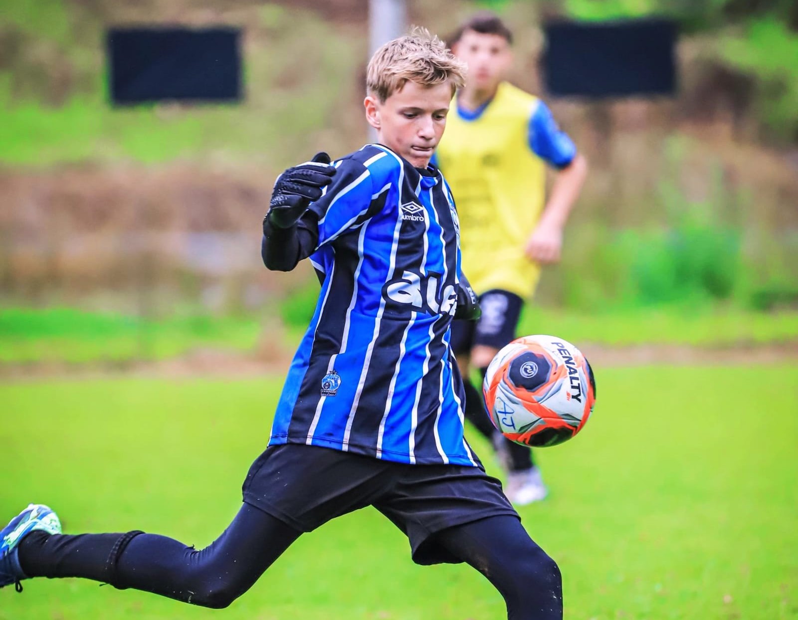 Jovem goleiro de Jaraguá do Sul chuta bola durante treino com uniforme do Grêmio