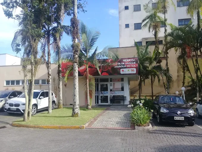 Fachada da unidade do HEMOSC em Jaraguá do Sul com entrada principal e carros estacionados