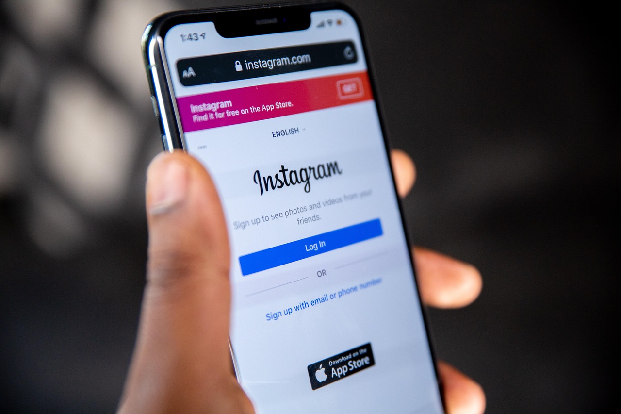 Pessoa com celular exibindo tela de login do Instagram, relacionado à nova classificação indicativa para maiores de 16 anos.
