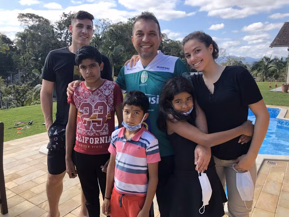 Francisco Koch com seus cinco filhos adotivos reunidos ao ar livre em Santa Catarina
