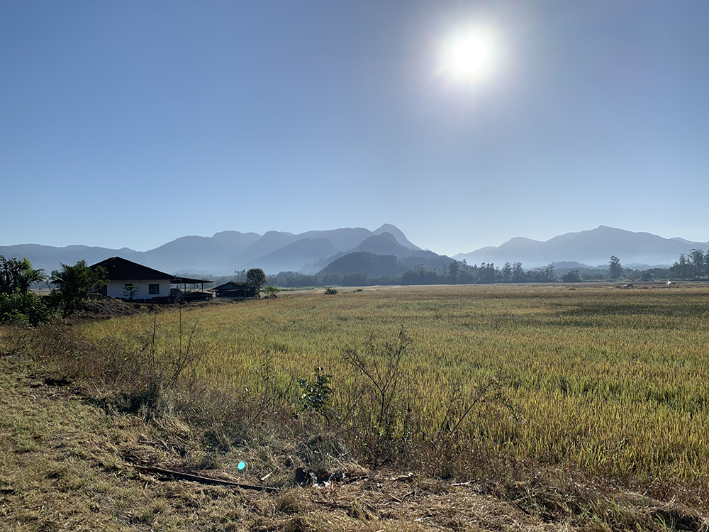 Casa rural com campo de plantação e montanhas ao fundo sob céu azul em Santa Luzia, Jaraguá do Sul