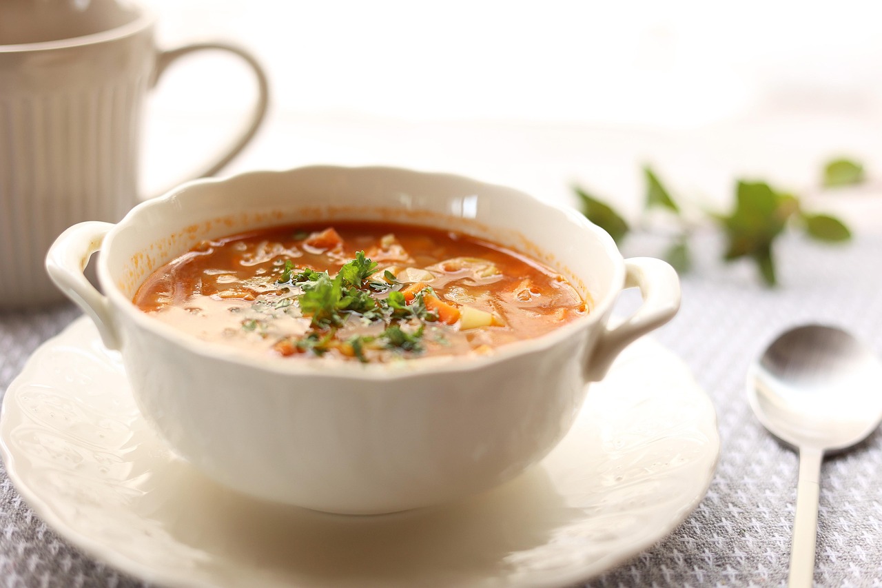 Prato de sopa cremosa servido em tigela rústica com pão ao lado