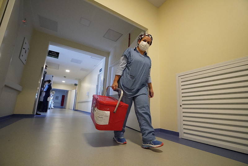 Ambiente hospitalar e pessoa carregando caixa de transplante de órgãos